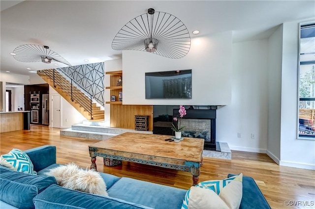 26171/2 Floyd Ave, Richmond, VA 23220 - living area featuring wood finished floors, stairs, recessed lighting, and a fireplace with raised hearth