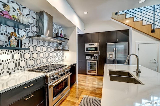 26171/2 Floyd Ave, Richmond, VA 23220 - kitchen featuring appliances with stainless steel finishes, wine cooler, extractor fan, tasteful backsplash, and light wood-type flooring