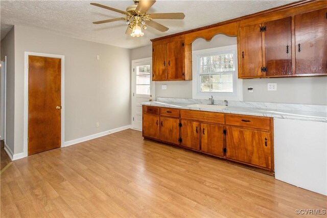 11512 Duncan Rd, Dinwiddie, VA 23805 - kitchen featuring a sink, light wood-style floors, light countertops, ceiling fan, and brown cabinetry