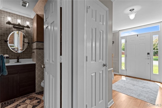1716 First Colonial Ct, Richmond, VA 23231 - entrance foyer with light wood finished floors, crown molding, and tile walls