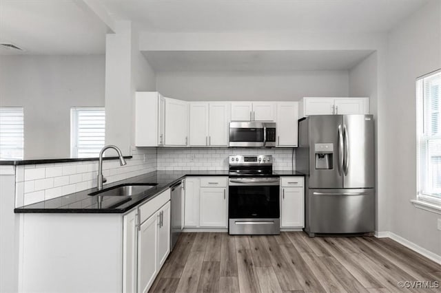 1317 N 22nd St, Richmond, VA 23223 - kitchen with stainless steel appliances, light wood-type flooring, and decorative backsplash
