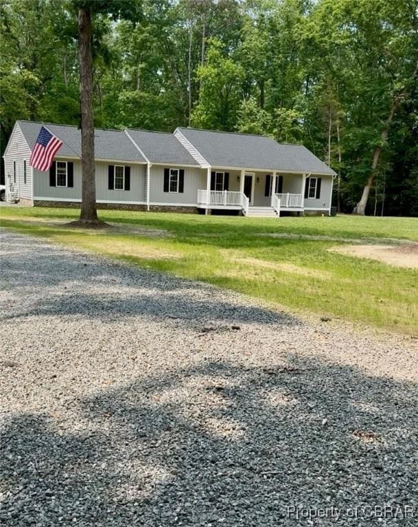 1205 Trimmers Shop Rd, West Point, VA 23181 - ranch-style home featuring driveway, covered porch, view of scattered trees, and a front lawn