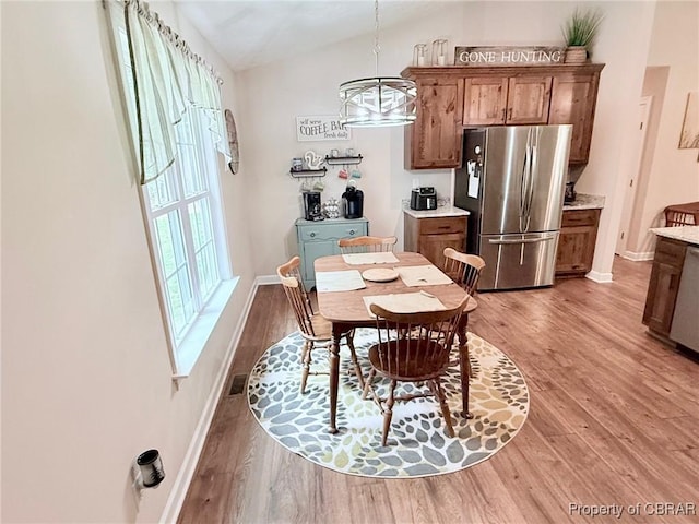 1205 Trimmers Shop Rd, West Point, VA 23181 - dining room featuring light wood-style floors, lofted ceiling, baseboards, and a chandelier