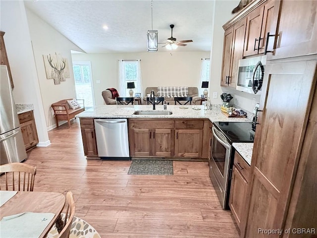1205 Trimmers Shop Rd, West Point, VA 23181 - kitchen featuring a sink, stainless steel appliances, a peninsula, ceiling fan, and light wood-style flooring