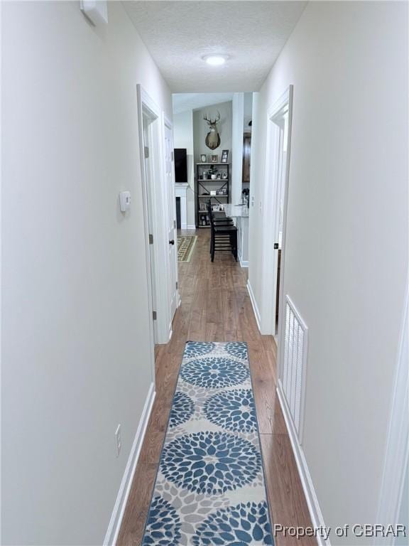 1205 Trimmers Shop Rd, West Point, VA 23181 - corridor with light wood finished floors, baseboards, and a textured ceiling