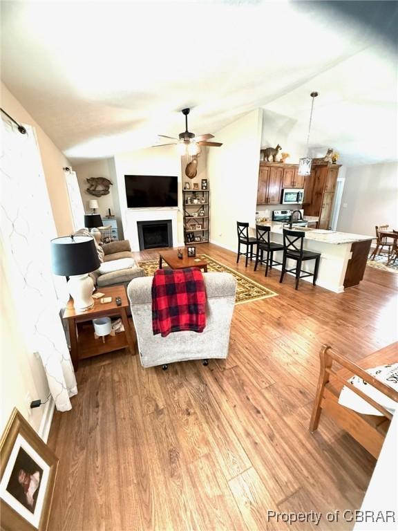 1205 Trimmers Shop Rd, West Point, VA 23181 - living area with a ceiling fan, wood finished floors, and a fireplace