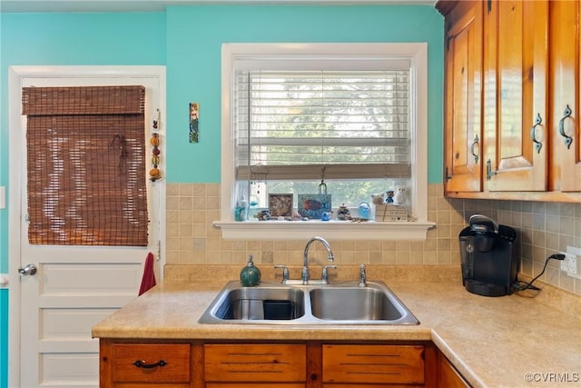 7143 Cherry Ln, Mechanicsville, VA 23111 - kitchen featuring a sink, light countertops, brown cabinetry, and tasteful backsplash