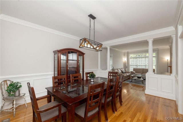 11407 Timber Point Dr, Chesterfield, VA 23838 - dining room featuring ornate columns, a decorative wall, crown molding, light wood-type flooring, and a wainscoted wall
