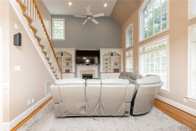 11407 Timber Point Dr, Chesterfield, VA 23838 - living room with high vaulted ceiling, a ceiling fan, wood finished floors, stairway, and a fireplace