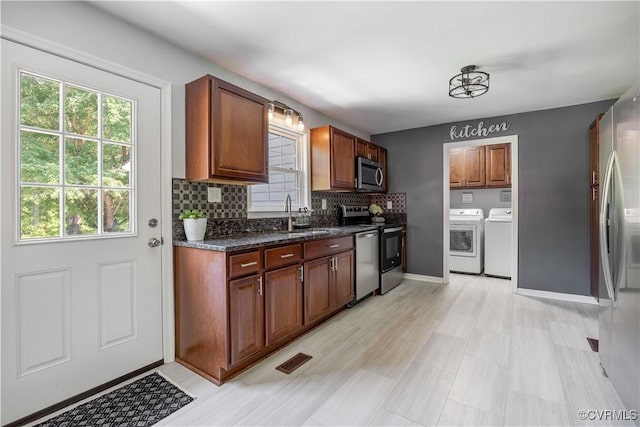 16701 Jolly Rd, Prince George, VA 23842 - kitchen with appliances with stainless steel finishes, washer and clothes dryer, tasteful backsplash, a sink, and baseboards