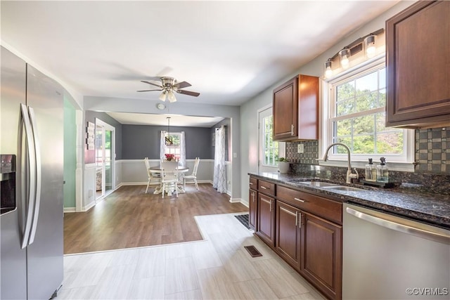 16701 Jolly Rd, Prince George, VA 23842 - kitchen with stainless steel appliances, a sink, dark stone counters, healthy amount of natural light, and wainscoting