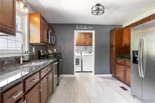 16701 Jolly Rd, Prince George, VA 23842 - kitchen with stainless steel appliances, independent washer and dryer, a sink, decorative backsplash, and dark stone countertops