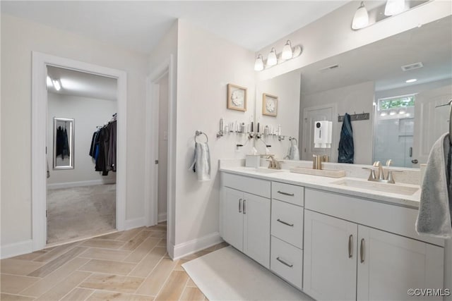6800 Alabaster Ln, Chesterfield, VA 23234 - bathroom featuring double vanity, baseboards, a walk in closet, and a stall shower