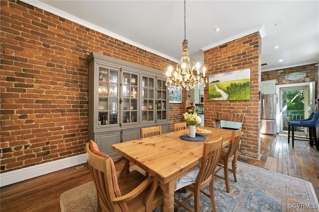 323 N 27th St, Richmond, VA 23223 - dining room featuring brick wall, dark wood-style floors, a chandelier, and crown molding
