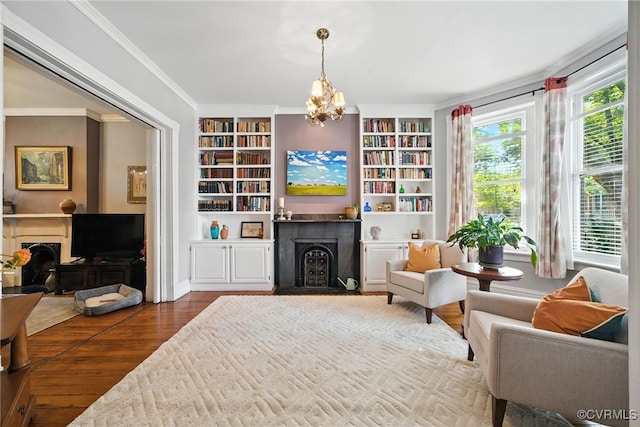 323 N 27th St, Richmond, VA 23223 - living area featuring a fireplace, a chandelier, built in shelves, wood finished floors, and ornamental molding