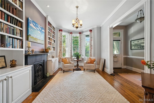 323 N 27th St, Richmond, VA 23223 - sitting room featuring hardwood / wood-style floors, a fireplace with flush hearth, a chandelier, ornamental molding, and built in features