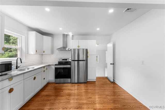 602 Trellis Ln, Henrico, VA 23075 - kitchen featuring appliances with stainless steel finishes, wall chimney range hood, a sink, white cabinets, and light stone counters