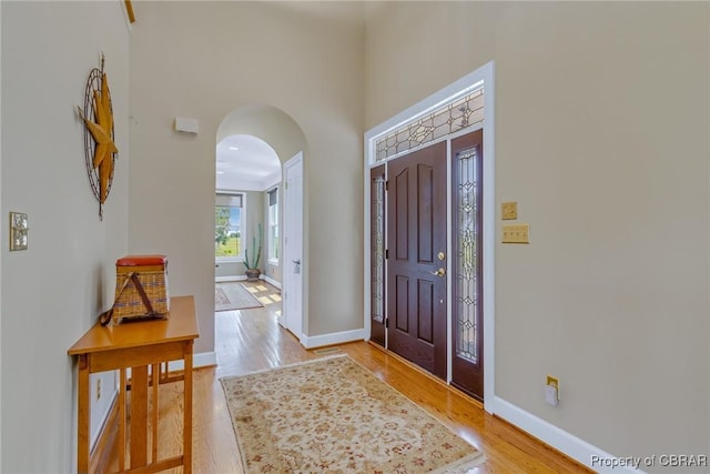 241 Tranquility Rd, Reedville, VA 22539 - foyer with arched walkways, light wood-style flooring, baseboards, and a towering ceiling