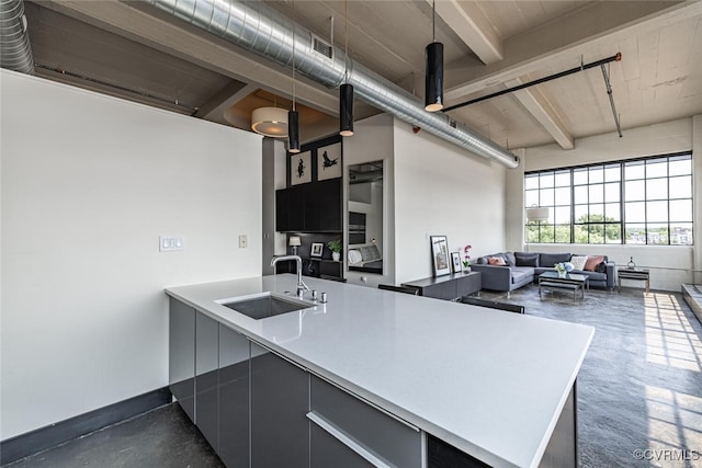 101 W Marshall St Unit U47, Richmond, VA 23220 - kitchen featuring a sink, finished concrete flooring, light countertops, open floor plan, and beam ceiling