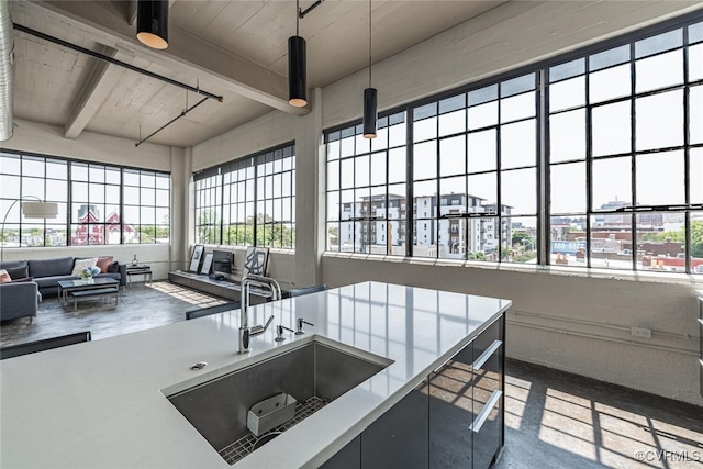 101 W Marshall St Unit U47, Richmond, VA 23220 - kitchen featuring a sink, healthy amount of natural light, open floor plan, decorative light fixtures, and wood ceiling with exposed beams