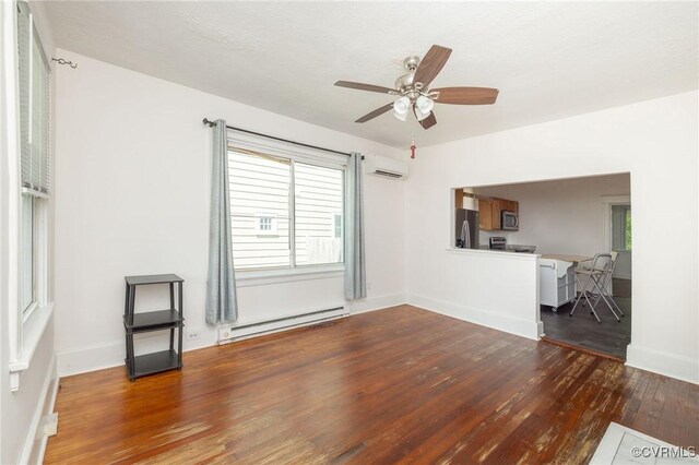 2007 Albany Ave, Richmond, VA 23224 - unfurnished living room featuring a baseboard heating unit, hardwood / wood-style floors, a wall mounted AC, ceiling fan, and healthy amount of natural light