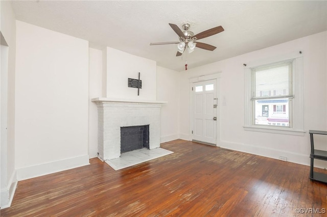 2007 Albany Ave, Richmond, VA 23224 - unfurnished living room with a ceiling fan, hardwood / wood-style floors, a brick fireplace, and baseboards