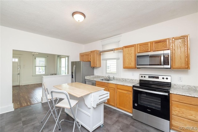 2007 Albany Ave, Richmond, VA 23224 - kitchen with stainless steel appliances, a sink, light countertops, plenty of natural light, and a textured ceiling