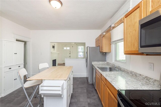 2007 Albany Ave, Richmond, VA 23224 - kitchen featuring stainless steel appliances, plenty of natural light, a kitchen breakfast bar, a sink, and a textured ceiling