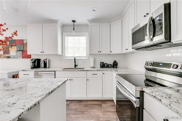 15606 Corte Castle Ter, Chesterfield, VA 23838 - kitchen featuring appliances with stainless steel finishes, a sink, white cabinetry, light wood-type flooring, and decorative backsplash