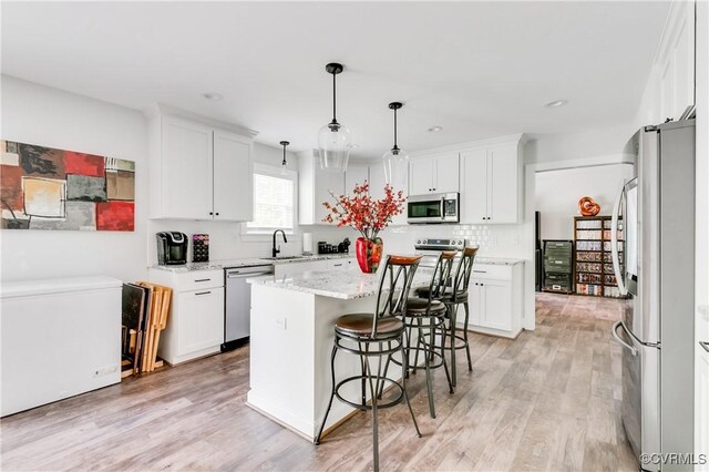 15606 Corte Castle Ter, Chesterfield, VA 23838 - kitchen featuring stainless steel appliances, a sink, white cabinets, a kitchen island, and light wood finished floors