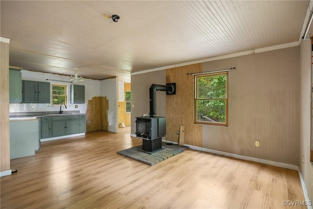 3966 Holts Ln, Saluda, VA 23149 - unfurnished living room with light wood-type flooring, a sink, ornamental molding, a wood stove, and baseboards