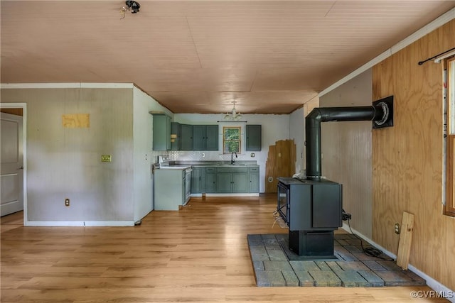 3966 Holts Ln, Saluda, VA 23149 - unfurnished living room with a wood stove, a sink, light wood finished floors, wood walls, and crown molding