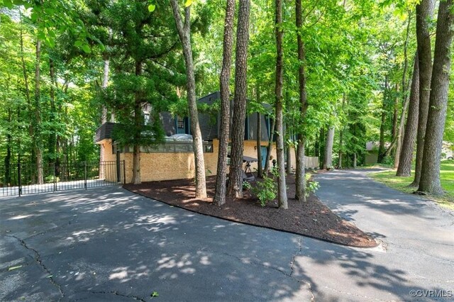 3301 E Princeton Rd, Petersburg, VA 23805 - view of front of home featuring driveway, brick siding, and a forest view