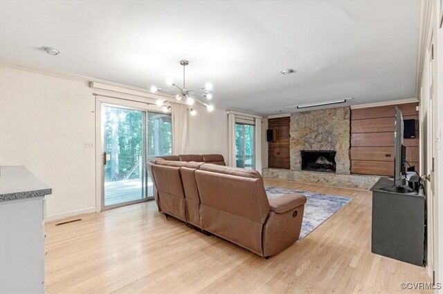 3301 E Princeton Rd, Petersburg, VA 23805 - living area with light wood-style floors, a stone fireplace, a chandelier, baseboards, and crown molding