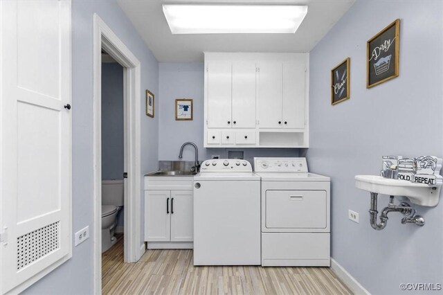 3301 E Princeton Rd, Petersburg, VA 23805 - laundry room with cabinet space, washing machine and clothes dryer, light wood-style flooring, and baseboards
