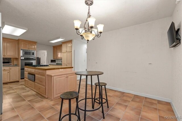3301 E Princeton Rd, Petersburg, VA 23805 - kitchen with appliances with stainless steel finishes, light brown cabinets, wooden counters, and a chandelier