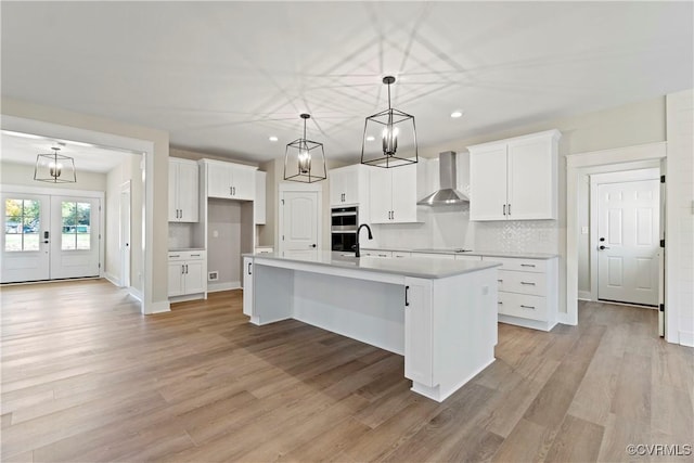 9027 Pine Hill Rd, Mechanicsville, VA 23116 - kitchen featuring wall chimney exhaust hood, stainless steel double oven, recessed lighting, a kitchen island with sink, and white cabinets
