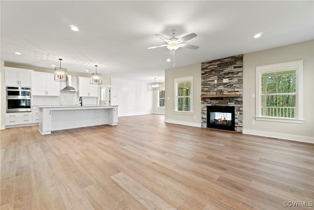 9027 Pine Hill Rd, Mechanicsville, VA 23116 - unfurnished living room featuring ceiling fan, a fireplace, recessed lighting, light wood-style floors, and a sink