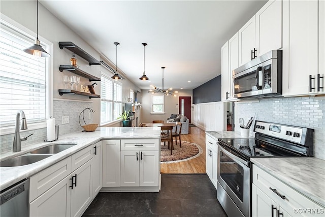 1815 Seddon Rd, Richmond, VA 23227 - kitchen with appliances with stainless steel finishes, a peninsula, white cabinets, and decorative backsplash