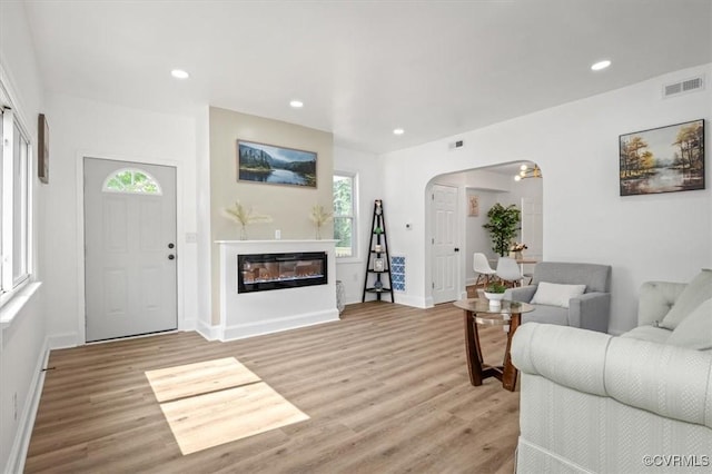 215 S S St, Petersburg, VA 23803 - living area featuring arched walkways, light wood finished floors, recessed lighting, a glass covered fireplace, and baseboards