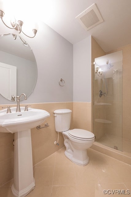 6 N 6th St Unit U3C, Richmond, VA 23219 - bathroom featuring toilet, tile patterned flooring, a shower stall, a sink, and wainscoting