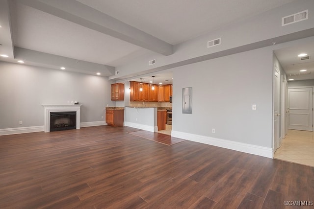 6 N 6th St Unit U3C, Richmond, VA 23219 - unfurnished living room featuring recessed lighting, wood finished floors, baseboards, a fireplace, and beamed ceiling