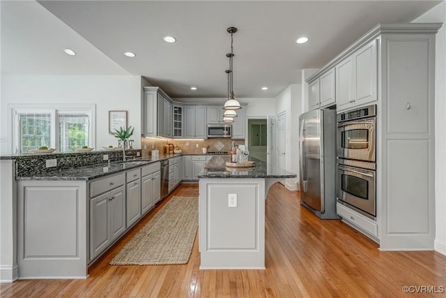 4307 Wilcot Dr, Midlothian, VA 23113 - kitchen with stainless steel appliances, gray cabinetry, a center island, a sink, and backsplash