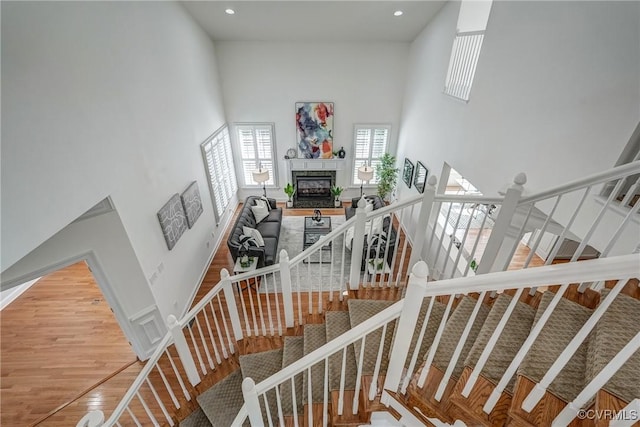 4307 Wilcot Dr, Midlothian, VA 23113 - stairway featuring a high ceiling, a glass covered fireplace, wood finished floors, and recessed lighting