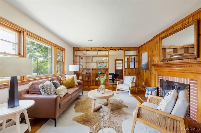 4212 Randolph Rd, North Chesterfield, VA 23236 - living room with wooden walls, wood finished floors, a brick fireplace, and a chandelier
