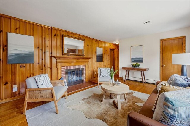 4212 Randolph Rd, North Chesterfield, VA 23236 - living room with wooden walls, light wood-style floors, a brick fireplace, and a baseboard radiator