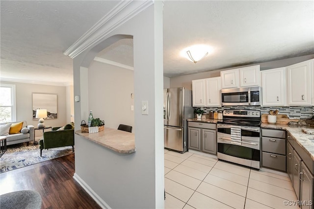 6406 Lothaire Ct, North Chesterfield, VA 23234 - kitchen with stainless steel appliances, arched walkways, ornamental molding, white cabinetry, and open floor plan