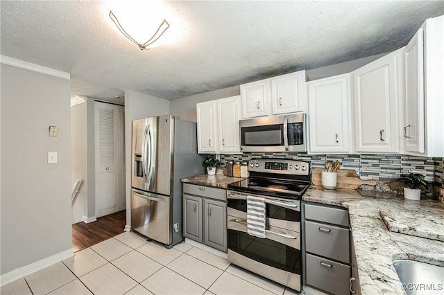 6406 Lothaire Ct, North Chesterfield, VA 23234 - kitchen with appliances with stainless steel finishes, decorative backsplash, white cabinetry, light tile patterned floors, and a textured ceiling