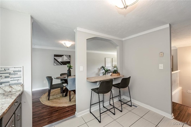 6406 Lothaire Ct, North Chesterfield, VA 23234 - dining area featuring arched walkways, ornamental molding, baseboards, and a textured ceiling