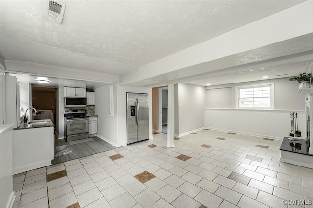 6406 Lothaire Ct, North Chesterfield, VA 23234 - kitchen featuring stainless steel appliances, a sink, a textured ceiling, white cabinets, and dark countertops